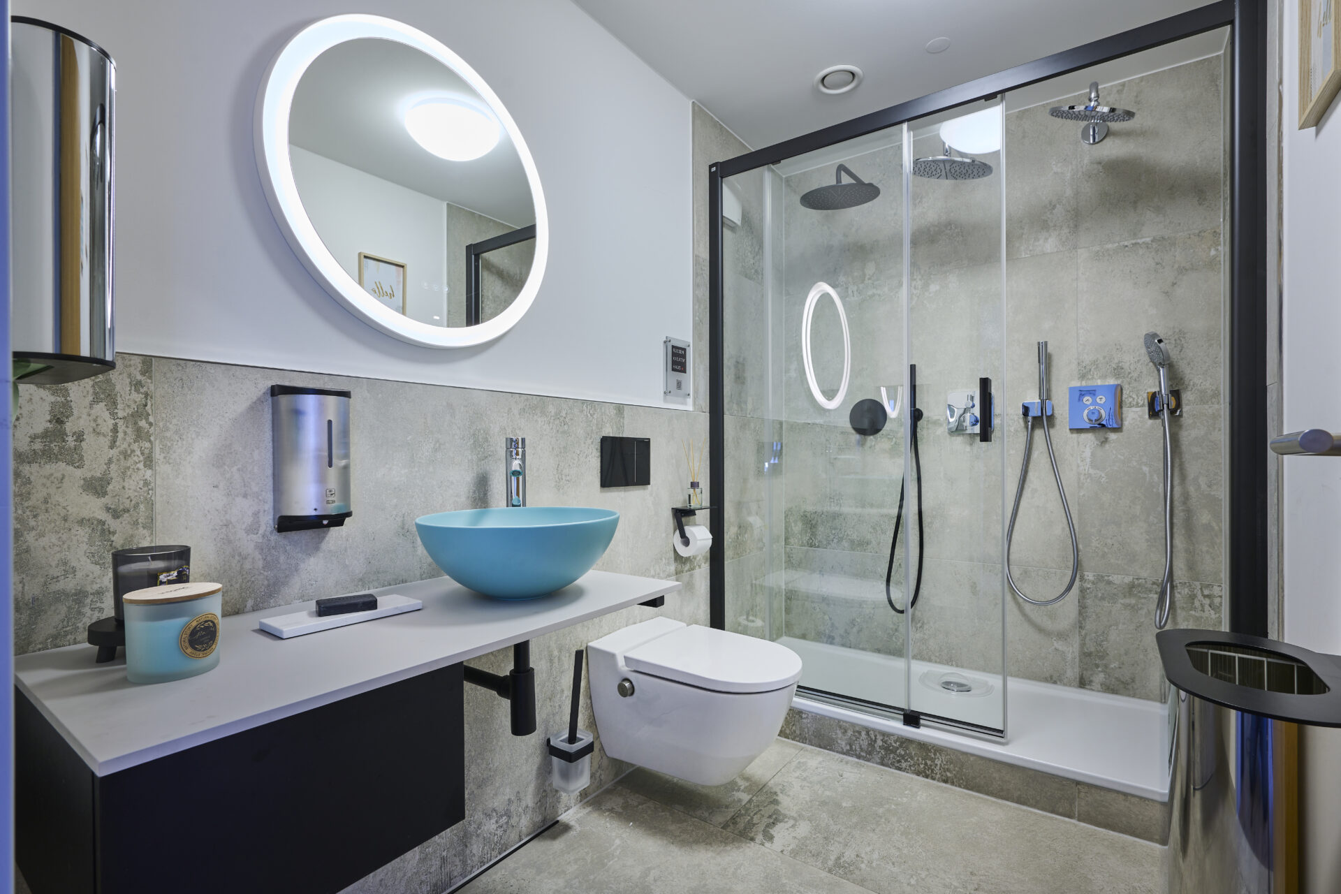 Ausstellung eines Bades - Duschkabine mit Glasfronten, einer Toilette und einem Waschtisch inkl. Spiegel