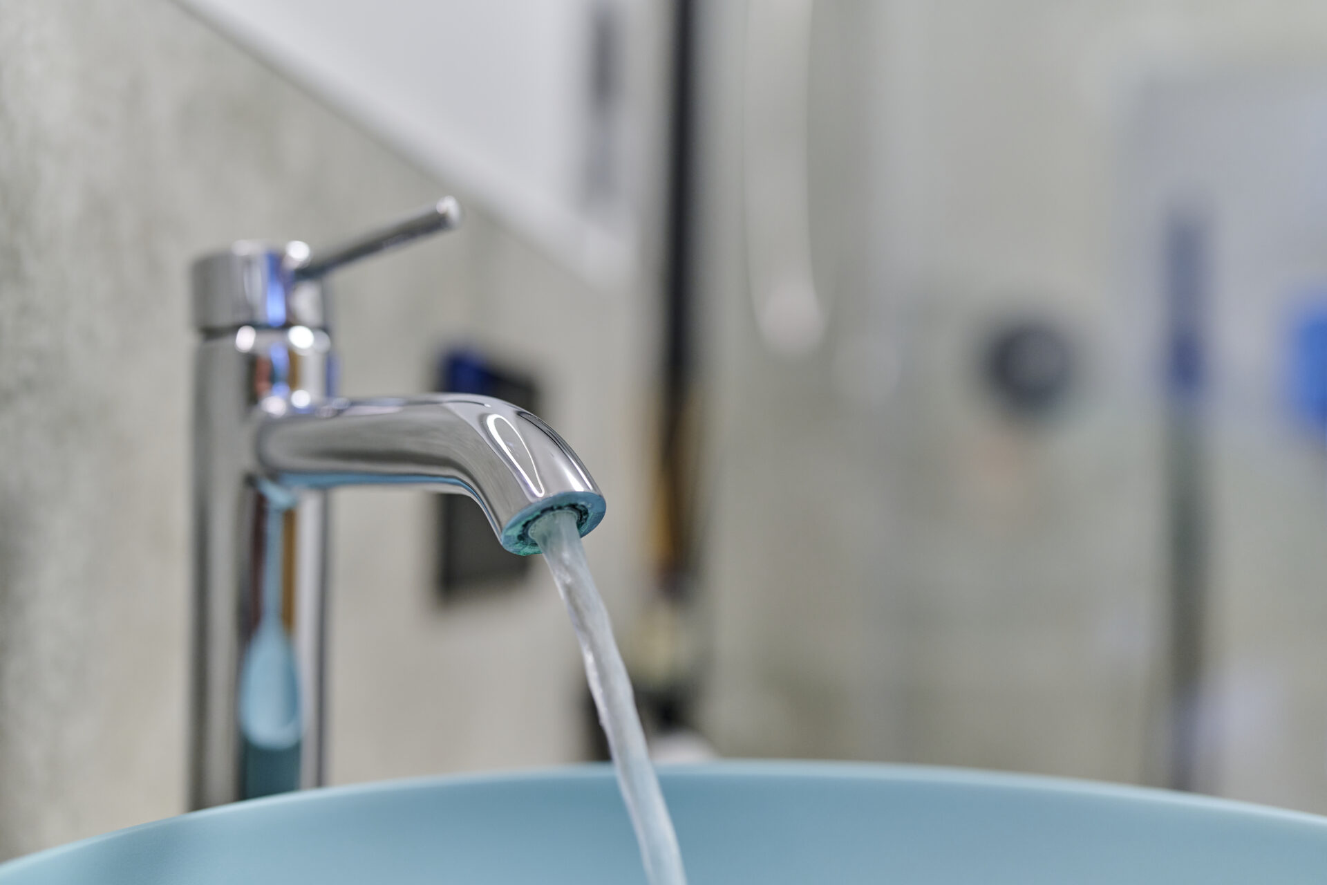 Wasser fließt vom Wasserhahn ins Waschbecken