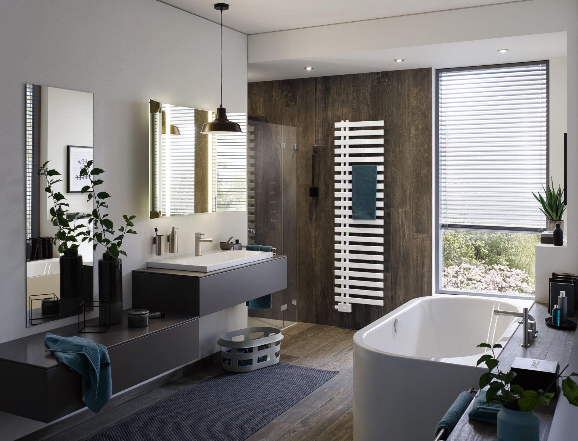 Badezimmer mit abgerundeter Badewanne, dunklem Waschtisch, Heizkörper für Handtücher und einer Duschkabine