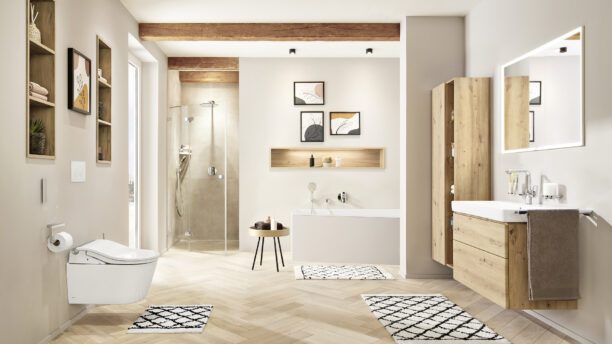 Auf dem Bild ist ein komplettes SANIBEL Badezimmer inkl. einer Badewanne, Dusche, einer Waschtischanlage und einem Dusch-WC zu sehen. Die Keramik ist in der Farbe weiß gehalten die Möbel sind in Naturholzfarben. Die Fliesen sind auch in Naturfarben gehalten.